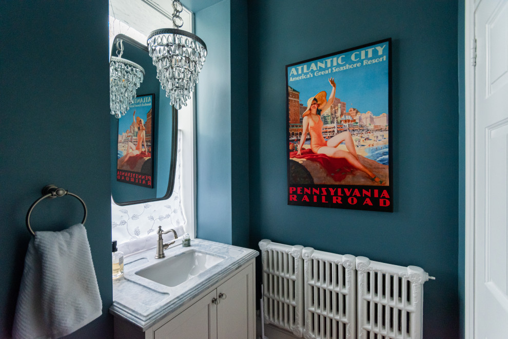 Kleine Klassische Gästetoilette mit Kassettenfronten, weißen Schränken, Toilette mit Aufsatzspülkasten, blauer Wandfarbe, braunem Holzboden, Unterbauwaschbecken, braunem Boden und eingebautem Waschtisch in Philadelphia