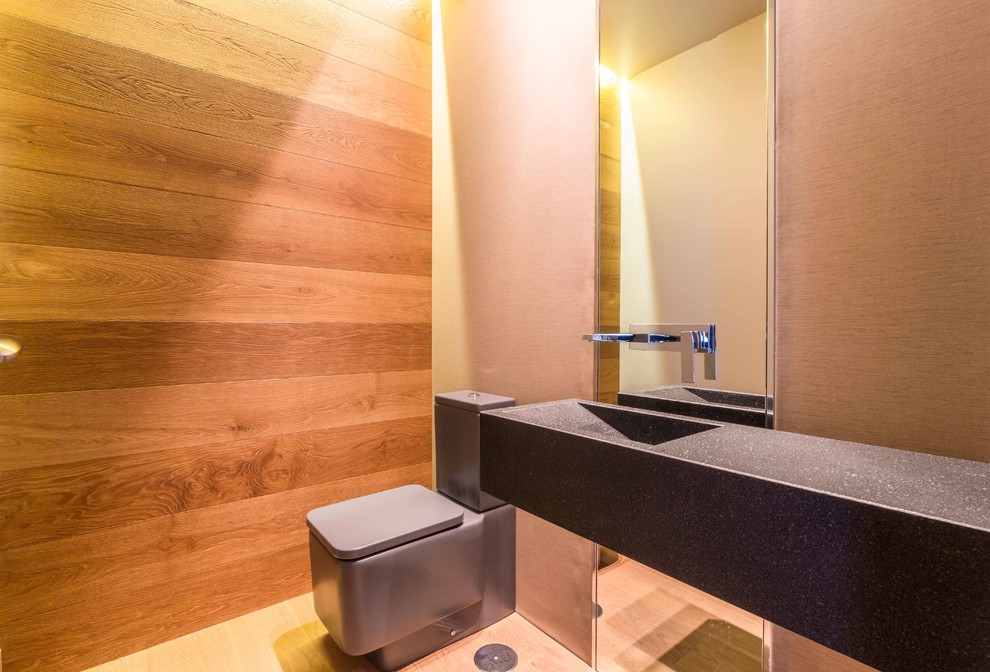 На фото: туалет среднего размера в современном стиле с раздельным унитазом, разноцветными стенами, светлым паркетным полом и монолитной раковиной с