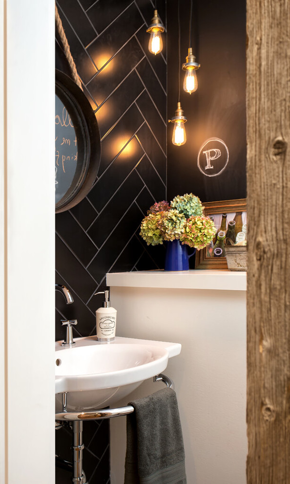 バンクーバーにある小さなインダストリアルスタイルのおしゃれなトイレ・洗面所 (壁付け型シンク、黒いタイル、磁器タイル、黒い壁) の写真