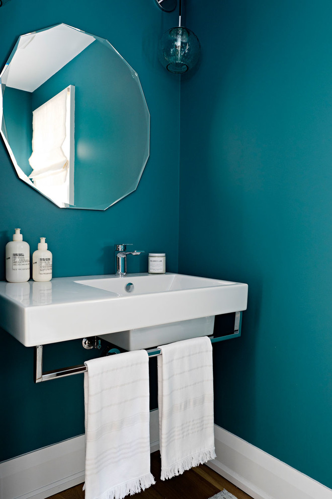 Cette image montre un petit WC et toilettes minimaliste avec un mur vert, parquet clair et un lavabo suspendu.