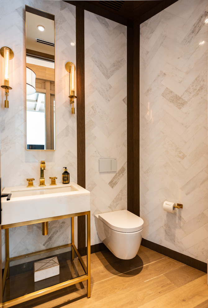 This is an example of a contemporary cloakroom in Miami with a wall mounted toilet, white tiles, brown walls, light hardwood flooring, a console sink and white worktops.