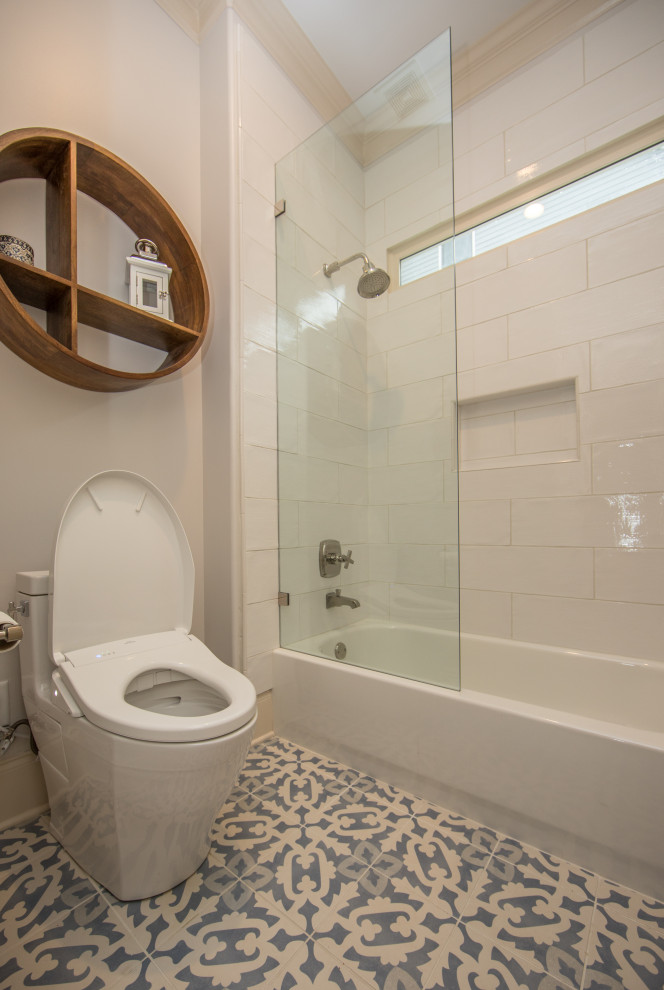 Photo of a medium sized bohemian cloakroom in Atlanta with freestanding cabinets, blue cabinets, a one-piece toilet, white tiles, ceramic tiles, white walls, porcelain flooring, a submerged sink, engineered stone worktops, blue floors, white worktops and a freestanding vanity unit.