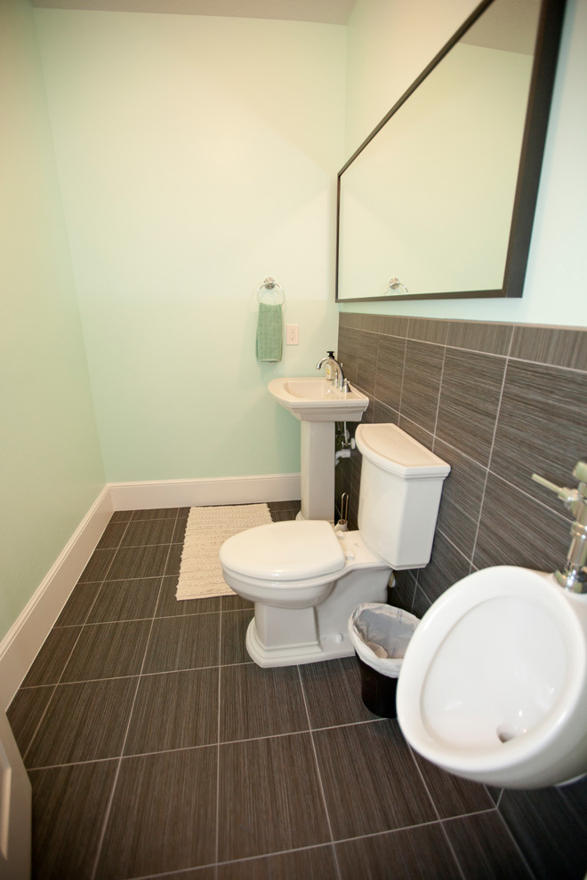 Cette image montre un petit WC et toilettes traditionnel avec un urinoir, un carrelage marron, des carreaux de céramique, un mur vert, un sol en carrelage de céramique, un lavabo de ferme et un sol marron.