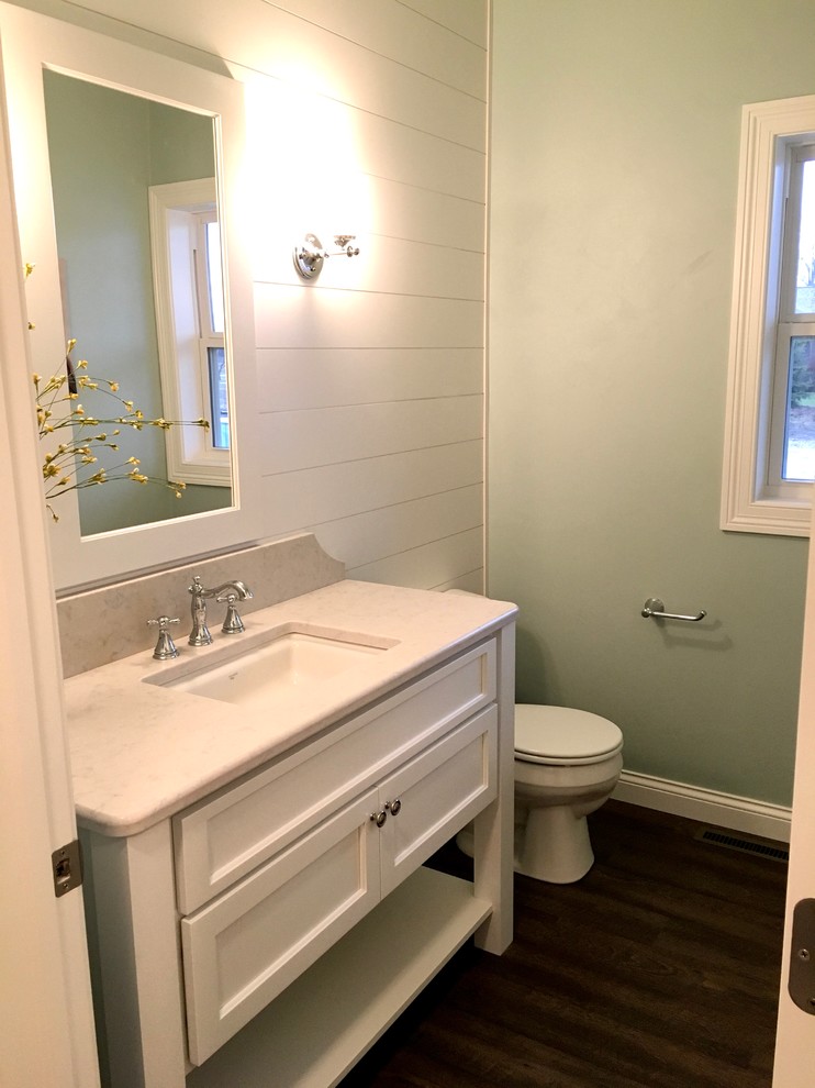 Пример оригинального дизайна: туалет в стиле кантри с белыми фасадами, зелеными стенами, полом из винила, врезной раковиной и столешницей из гранита