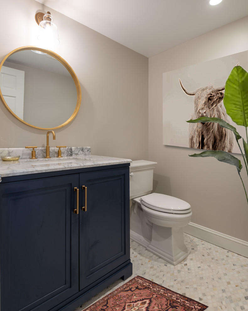 Cette image montre un petit WC et toilettes traditionnel avec un placard avec porte à panneau encastré, des portes de placard bleues, WC séparés, un mur gris, un sol en carrelage de porcelaine, un lavabo posé, un plan de toilette en marbre, un sol gris et un plan de toilette blanc.
