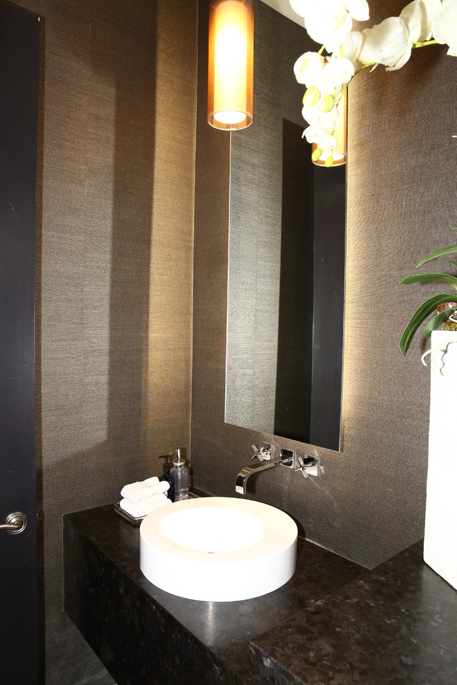 Kleine Moderne Gästetoilette mit flächenbündigen Schrankfronten, schwarzen Schränken, brauner Wandfarbe, Aufsatzwaschbecken, Granit-Waschbecken/Waschtisch und schwarzer Waschtischplatte in Sonstige