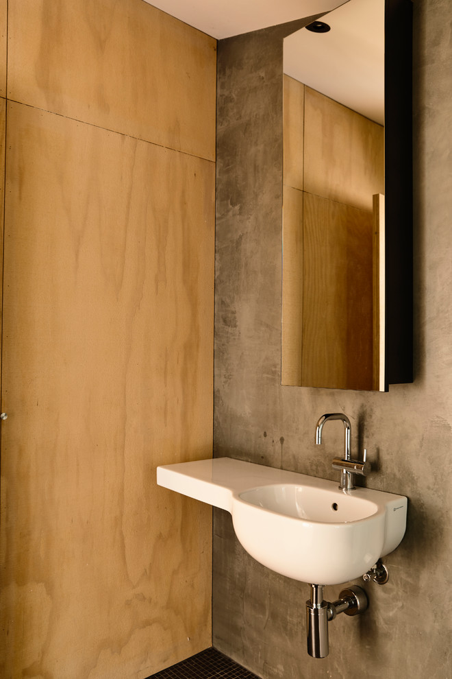 Foto di un bagno di servizio design con pareti grigie, pavimento con piastrelle a mosaico, lavabo sospeso e pavimento nero