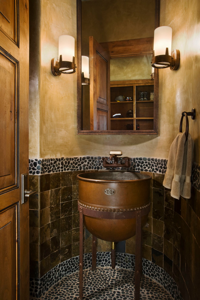 他の地域にあるラスティックスタイルのおしゃれなトイレ・洗面所 (ペデスタルシンク、茶色いタイル、石タイル) の写真