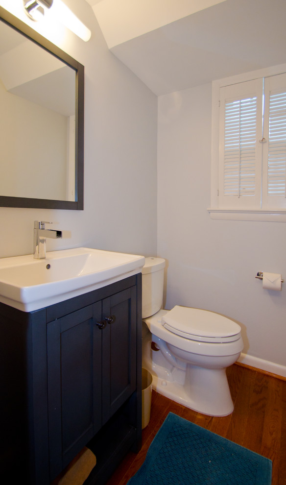 Inspiration for a medium sized classic cloakroom in DC Metro with shaker cabinets, blue cabinets, a two-piece toilet, grey walls, medium hardwood flooring and a built-in sink.