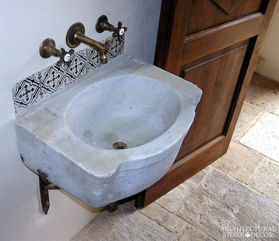 Immagine di un piccolo bagno di servizio mediterraneo con pavimento in pietra calcarea, lavabo sospeso e top in pietra calcarea