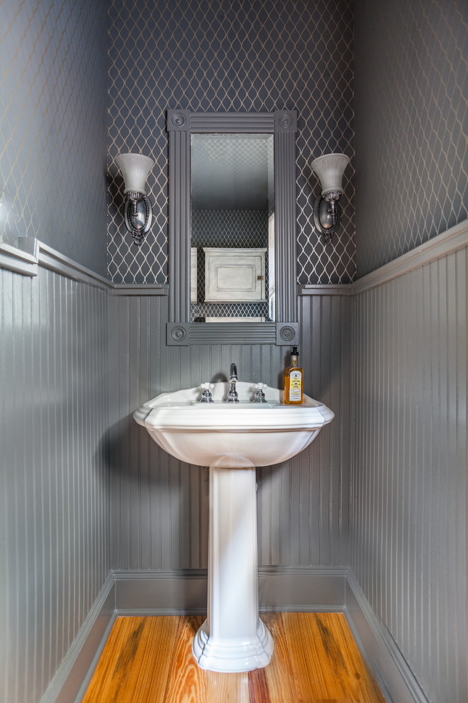 Diseño de aseo tradicional grande con lavabo con pedestal, paredes grises y suelo de madera en tonos medios