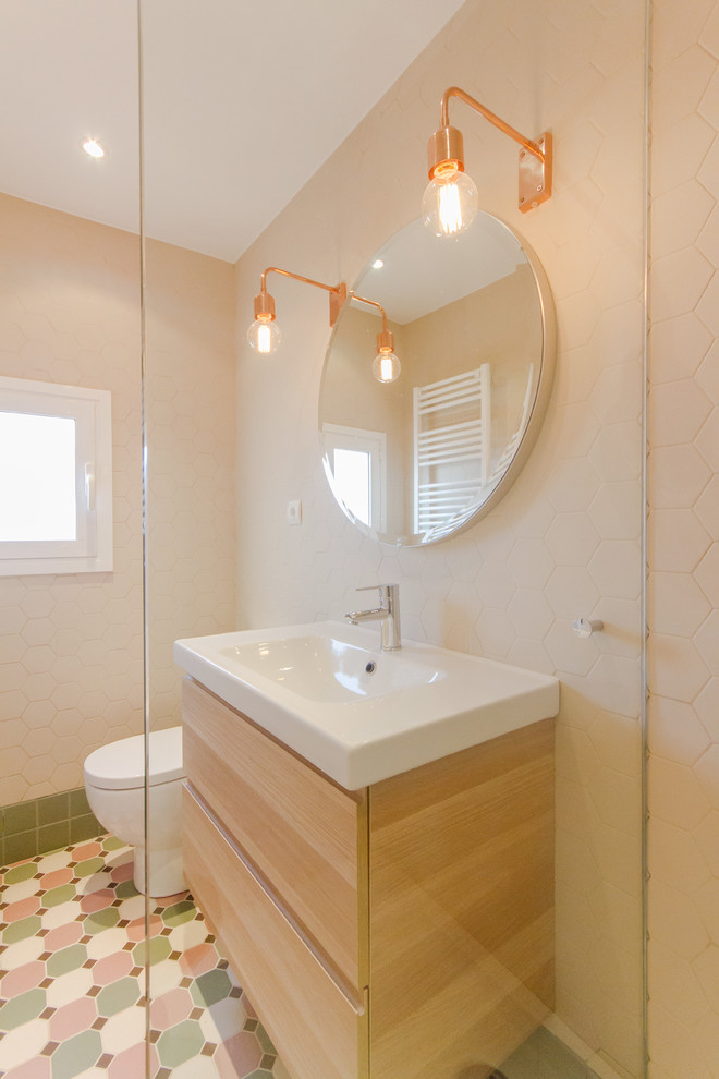 Esempio di un bagno di servizio nordico di medie dimensioni con ante lisce, ante in legno chiaro, WC monopezzo, piastrelle in ceramica, pareti beige, pavimento con piastrelle in ceramica e lavabo integrato