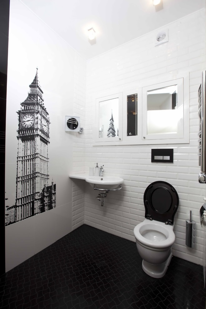 Immagine di un bagno di servizio tradizionale con WC a due pezzi, piastrelle bianche, pistrelle in bianco e nero, piastrelle nere, pareti bianche, pavimento con piastrelle in ceramica, lavabo sospeso e pavimento nero