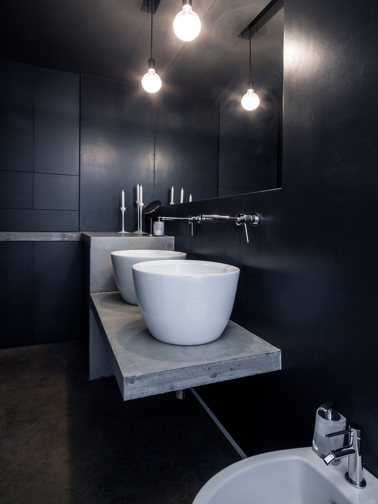 Imagen de aseo actual pequeño con bidé, baldosas y/o azulejos negros, paredes negras, lavabo sobreencimera, encimera de granito y suelo negro