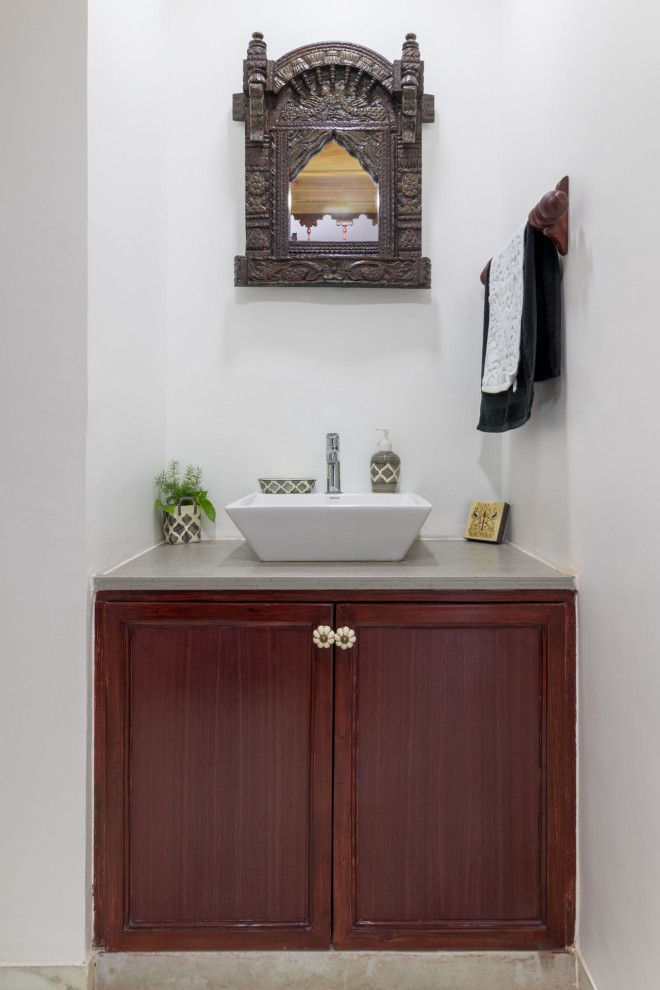 Foto di un piccolo bagno di servizio tradizionale con ante con riquadro incassato, ante in legno scuro, pareti bianche, lavabo a bacinella, pavimento grigio, top grigio e mobile bagno incassato