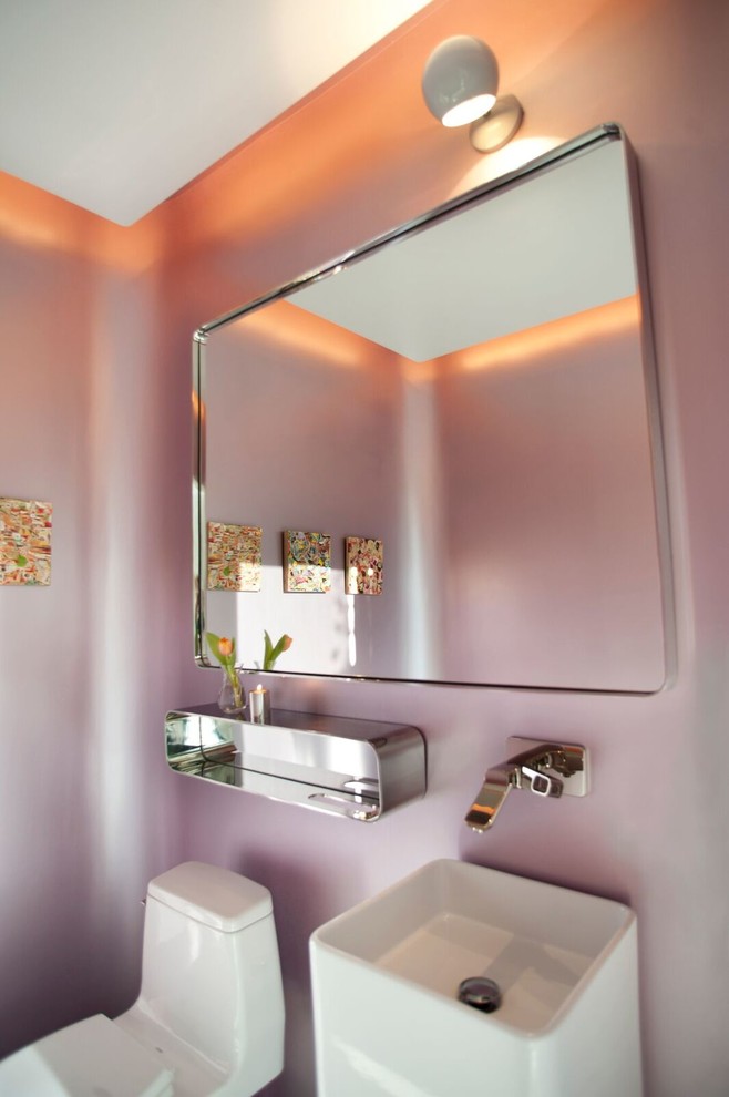 Idées déco pour un WC et toilettes contemporain avec WC à poser, un mur rose et un lavabo intégré.