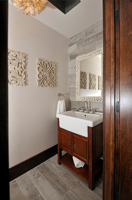 他の地域にあるトラディショナルスタイルのおしゃれなトイレ・洗面所 (グレーのタイル、木目調タイル、磁器タイルの床) の写真
