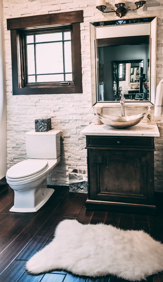 Idéer för att renovera ett rustikt vit vitt toalett, med luckor med infälld panel, skåp i mörkt trä, en toalettstol med separat cisternkåpa, vit kakel, stenkakel, beige väggar, laminatgolv, ett fristående handfat, granitbänkskiva och brunt golv