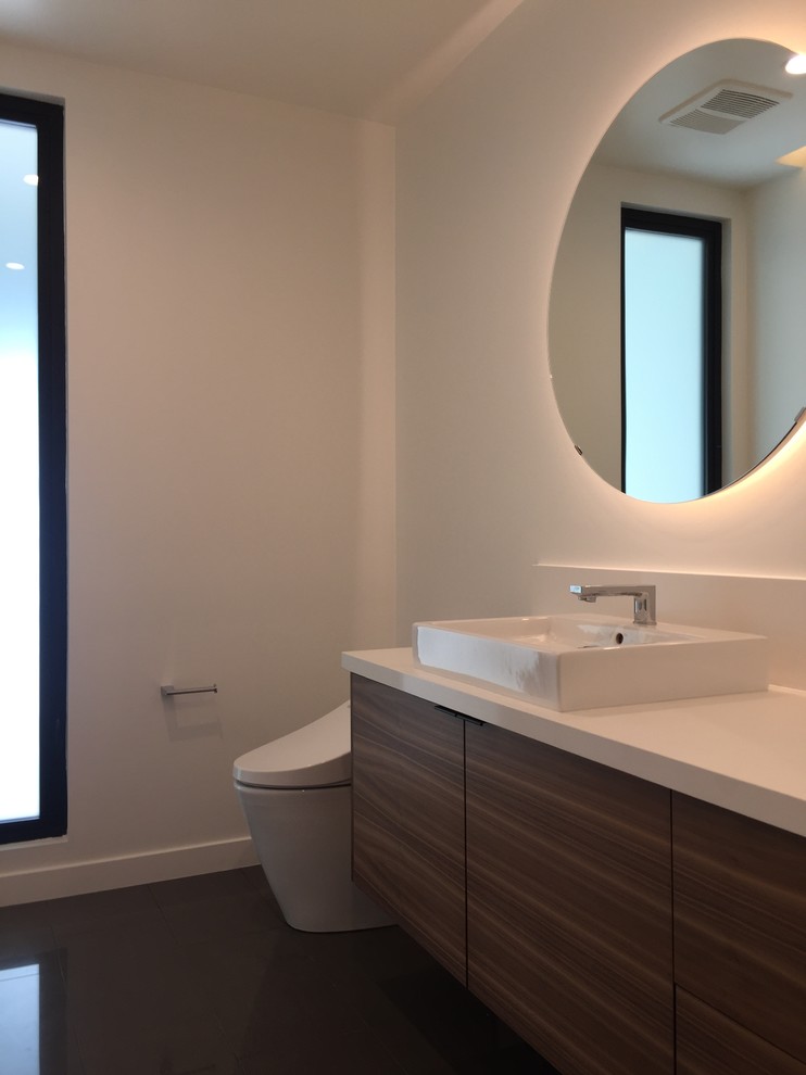 Aménagement d'un WC et toilettes moderne en bois brun de taille moyenne avec un placard à porte plane, un bidet, un carrelage blanc, un mur blanc, un sol en carrelage de porcelaine, une vasque, un plan de toilette en quartz modifié, un sol gris et un plan de toilette blanc.
