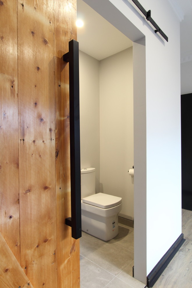 Mittelgroße Industrial Gästetoilette mit hellen Holzschränken, Toilette mit Aufsatzspülkasten, grauen Fliesen, Porzellanfliesen, grauer Wandfarbe, Porzellan-Bodenfliesen und Quarzwerkstein-Waschtisch in Melbourne