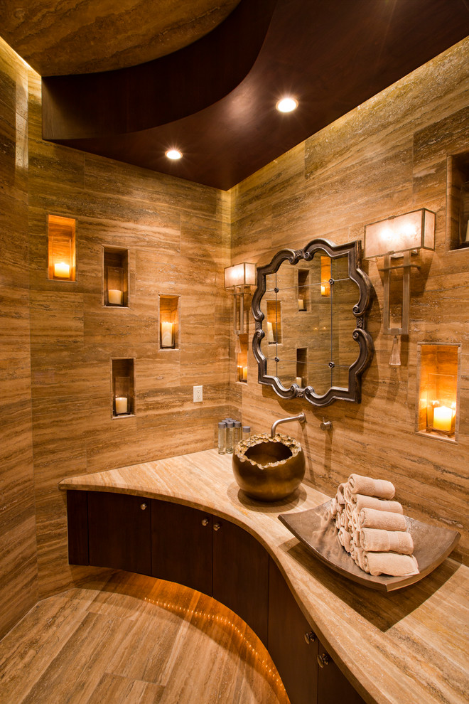 Foto på ett mellanstort medelhavsstil toalett, med släta luckor, skåp i mörkt trä, beige kakel, vinylgolv, ett fristående handfat, marmorbänkskiva och bruna väggar