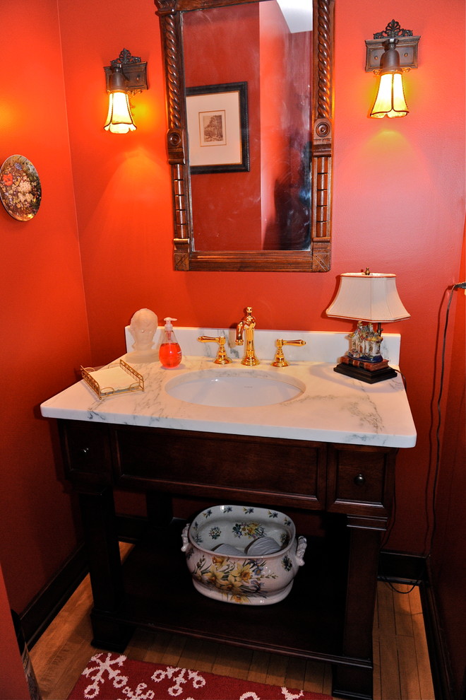 Design ideas for a medium sized traditional cloakroom in Chicago with freestanding cabinets, dark wood cabinets, a two-piece toilet, red walls, medium hardwood flooring, a submerged sink and marble worktops.