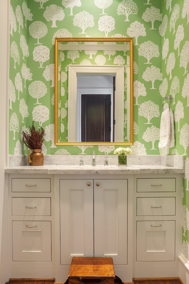 На фото: туалет в классическом стиле с фасадами с декоративным кантом, белыми фасадами, мраморной столешницей и зелеными стенами