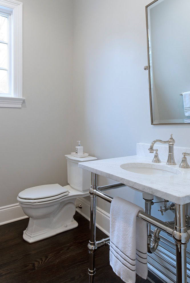 Ispirazione per un piccolo bagno di servizio tradizionale con lavabo sottopiano, top in marmo, WC a due pezzi, pareti grigie e pavimento in legno massello medio