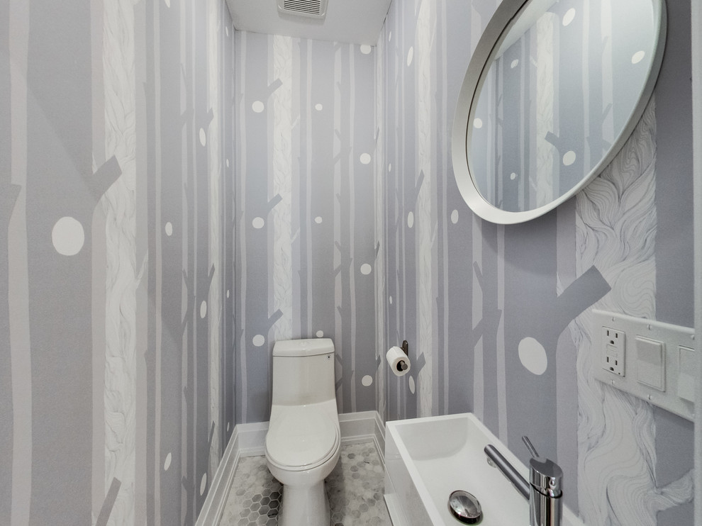 Foto på ett litet funkis toalett, med en toalettstol med hel cisternkåpa, grå väggar, marmorgolv, ett integrerad handfat och grått golv