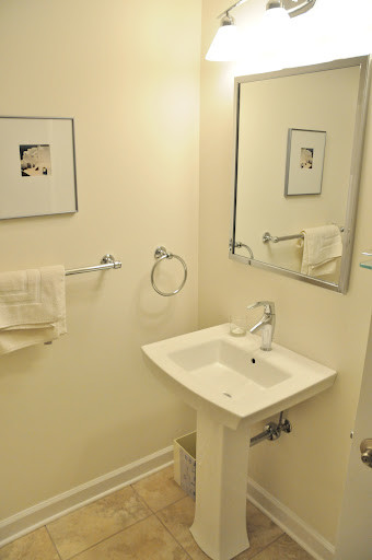 ボルチモアにあるお手頃価格の小さなトラディショナルスタイルのおしゃれなトイレ・洗面所 (一体型トイレ	、白い壁、トラバーチンの床、ペデスタルシンク) の写真