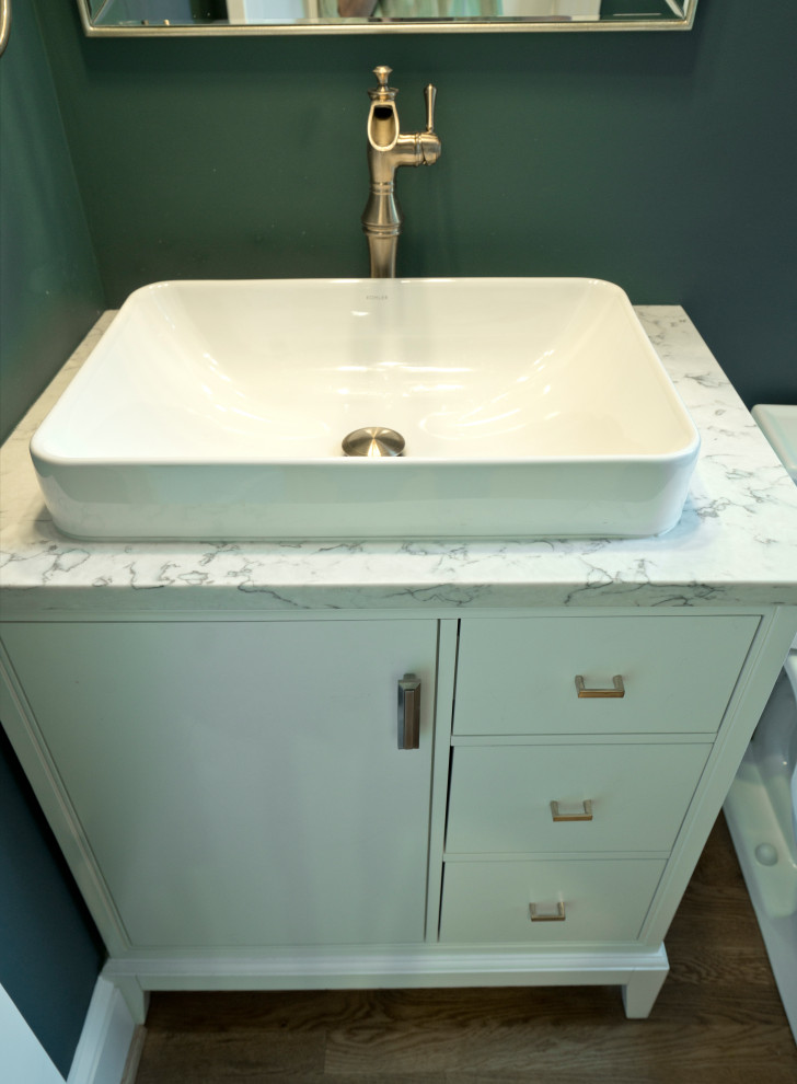 Moderne Gästetoilette mit weißen Schränken, blauer Wandfarbe, braunem Holzboden, Aufsatzwaschbecken, Quarzwerkstein-Waschtisch und weißer Waschtischplatte in Washington, D.C.
