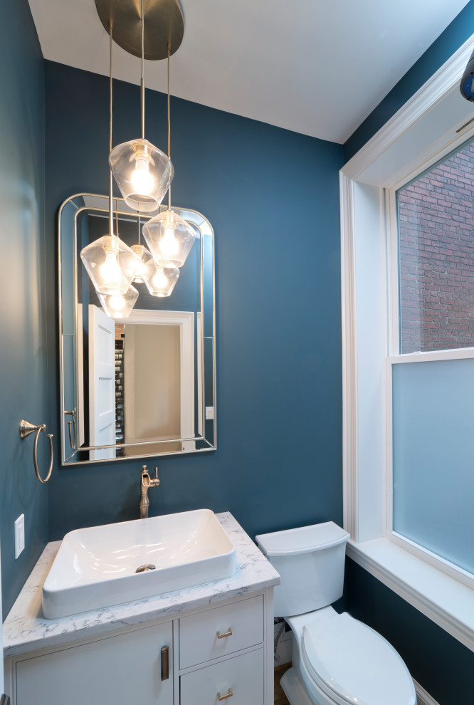 Inspiration pour un WC et toilettes minimaliste avec des portes de placard blanches, WC séparés, un mur bleu, un sol en bois brun, une vasque, un plan de toilette en quartz modifié et un plan de toilette blanc.