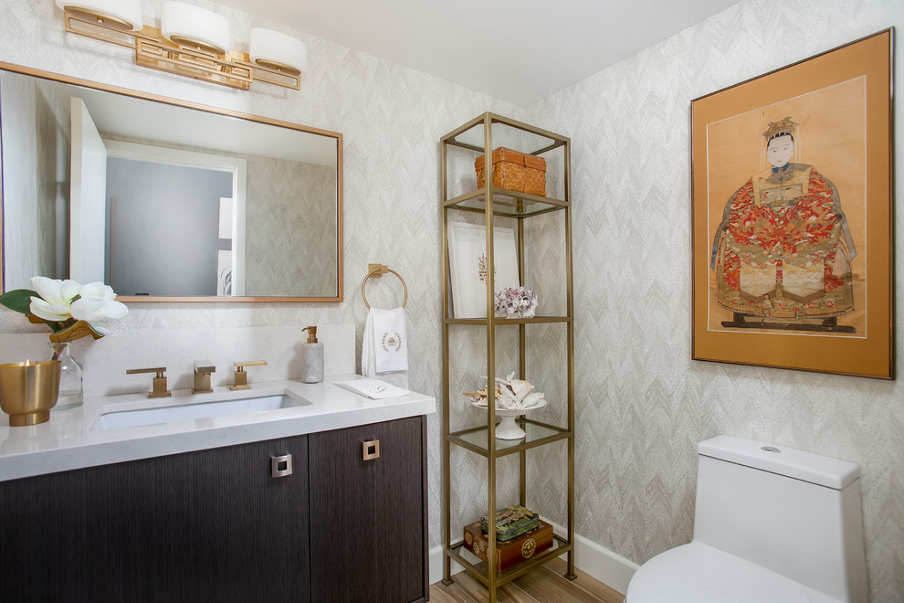 Foto di un bagno di servizio chic con ante lisce, ante in legno bruno, WC monopezzo, pareti grigie, lavabo sottopiano e pavimento marrone