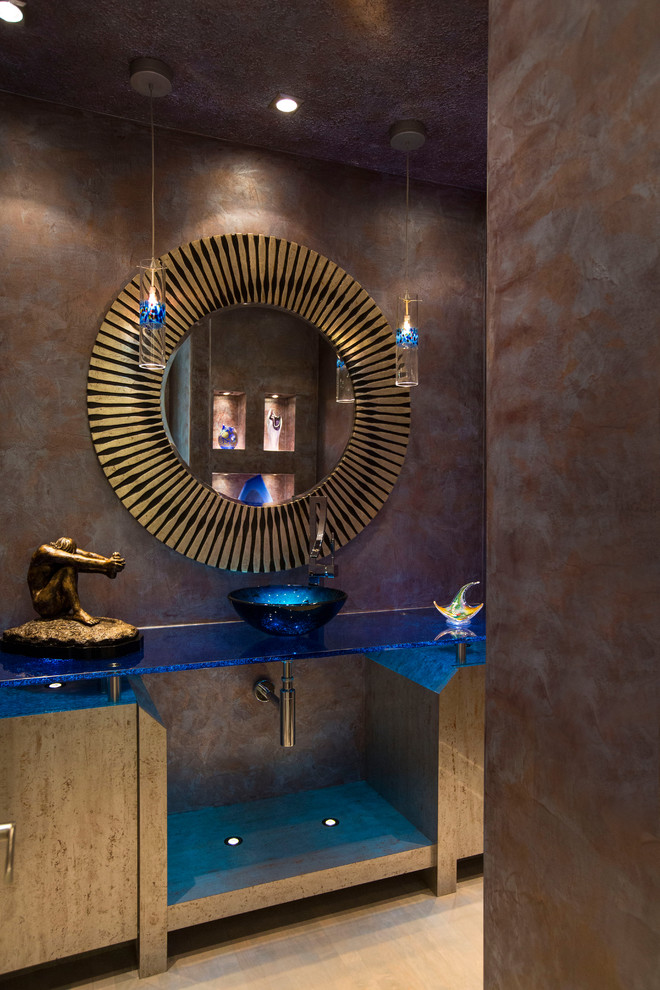 Пример оригинального дизайна: туалет в современном стиле с настольной раковиной, стеклянной столешницей и синей столешницей
