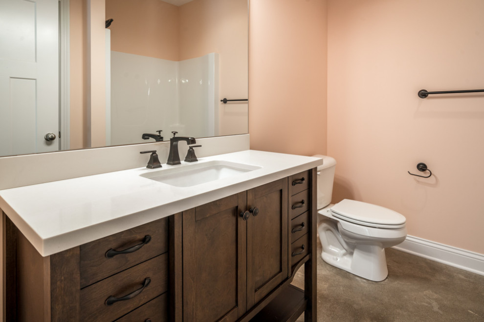 Idée de décoration pour un WC et toilettes tradition en bois brun avec un placard en trompe-l'oeil, WC séparés, un mur rose, sol en béton ciré, un lavabo posé, un plan de toilette en surface solide, un sol gris, un plan de toilette blanc et meuble-lavabo sur pied.