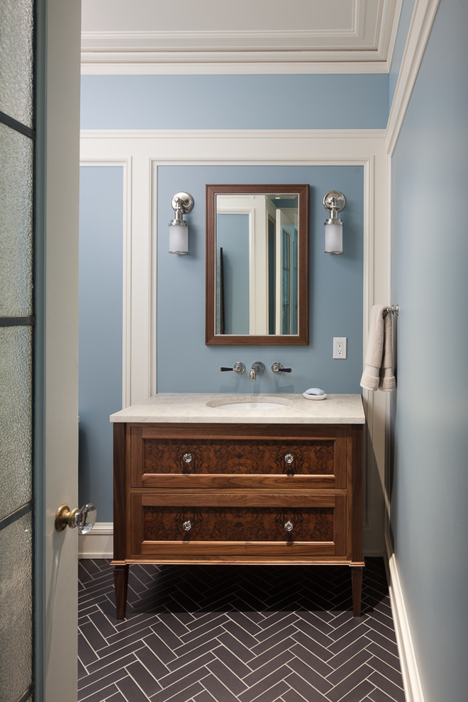 This is an example of a traditional cloakroom in Seattle with freestanding cabinets, dark wood cabinets, blue walls, a submerged sink, black floors and beige worktops.