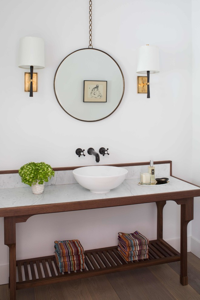 Inspiration for a medium sized farmhouse cloakroom in Los Angeles with freestanding cabinets, medium wood cabinets, white walls, light hardwood flooring, a vessel sink, marble worktops and white worktops.