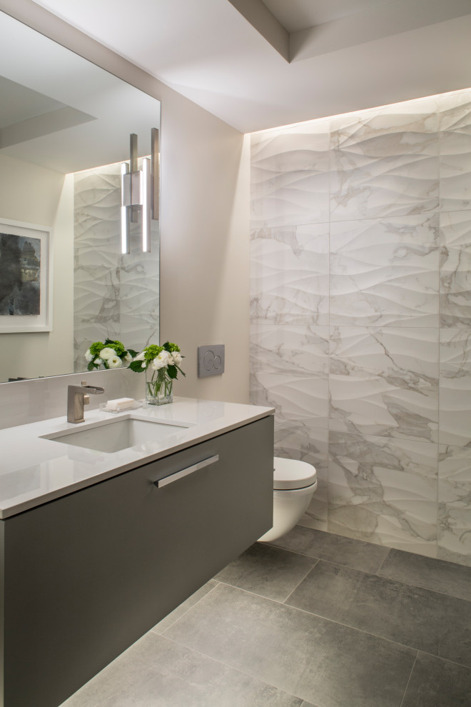 Immagine di un bagno di servizio minimal con ante lisce, ante grigie, piastrelle multicolore, pareti beige, lavabo sottopiano, pavimento grigio e top bianco