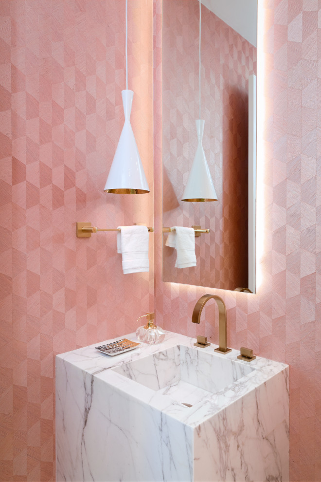Modelo de aseo contemporáneo con paredes rosas, lavabo integrado y encimeras blancas