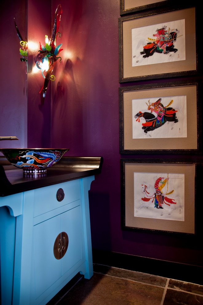 ソルトレイクシティにあるアジアンスタイルのおしゃれなトイレ・洗面所 (ベッセル式洗面器、青いキャビネット、木製洗面台、紫の壁) の写真