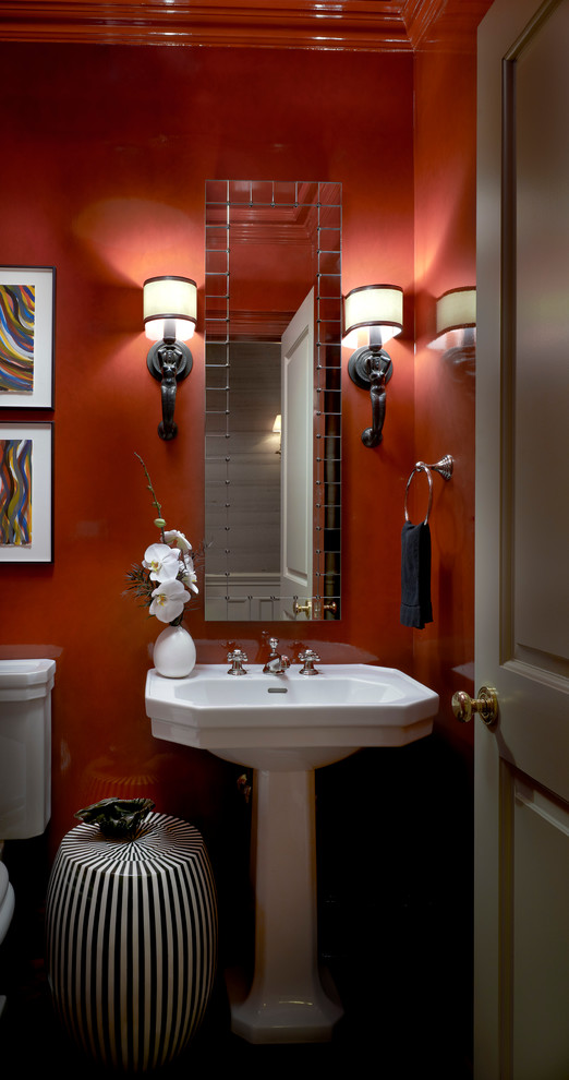 Klassisk inredning av ett litet toalett, med ett piedestal handfat och röda väggar