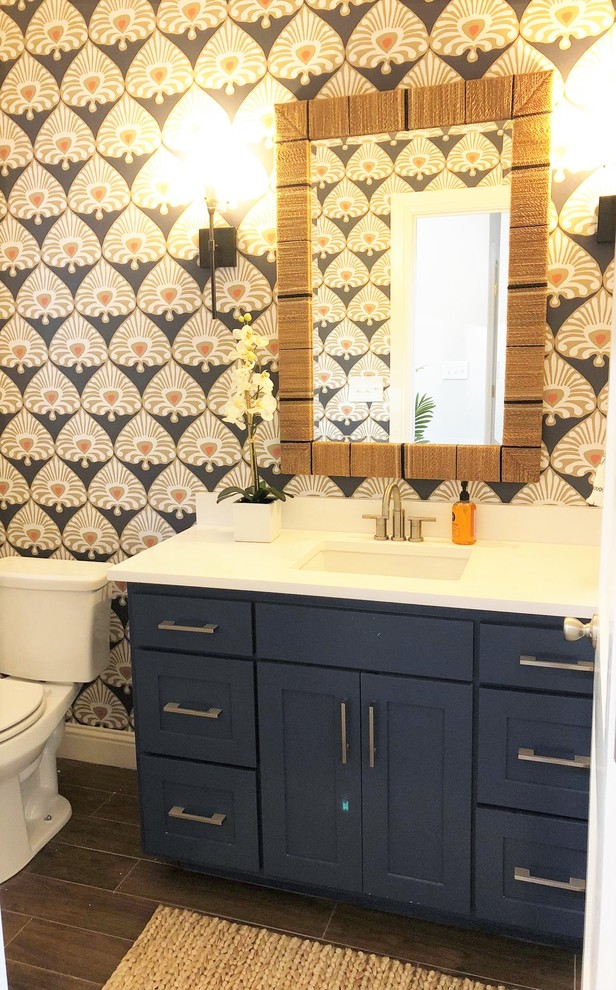 Kleine Eklektische Gästetoilette mit Schrankfronten mit vertiefter Füllung, blauen Schränken, Toilette mit Aufsatzspülkasten, blauer Wandfarbe, Keramikboden, Unterbauwaschbecken, Quarzit-Waschtisch, braunem Boden und weißer Waschtischplatte in Dallas