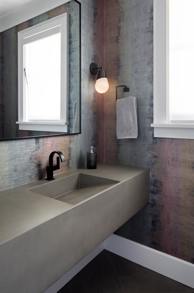 На фото: туалет в стиле неоклассика (современная классика) с разноцветными стенами, монолитной раковиной, черным полом, серой столешницей и обоями на стенах