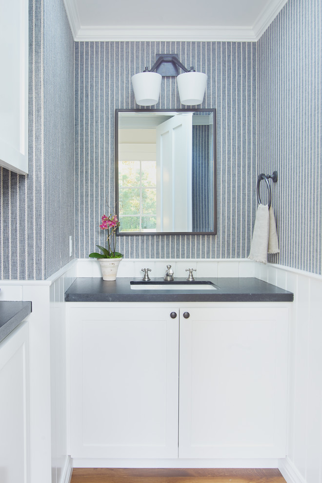 Foto på ett litet vintage toalett, med skåp i shakerstil, vita skåp, blå väggar, mellanmörkt trägolv, ett undermonterad handfat, granitbänkskiva och brunt golv