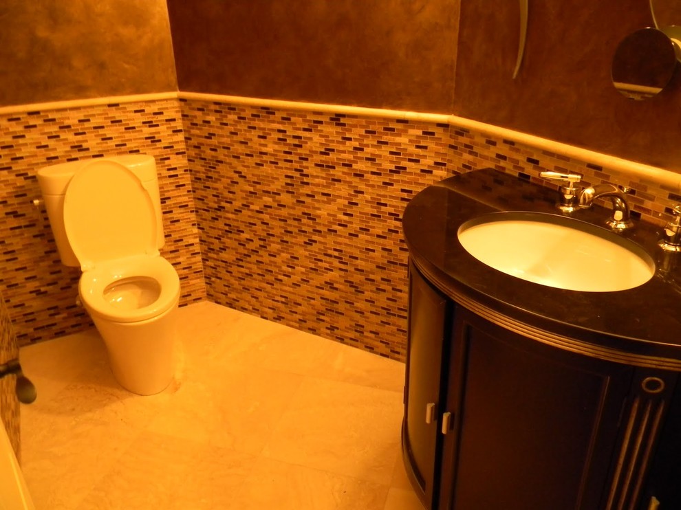Photo of a small contemporary cloakroom in Atlanta with freestanding cabinets, dark wood cabinets, a one-piece toilet, multi-coloured tiles, glass tiles, brown walls, limestone flooring, a submerged sink and beige floors.