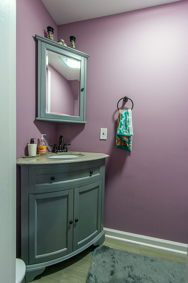 Idées déco pour un petit WC et toilettes contemporain avec un lavabo encastré, un placard avec porte à panneau encastré, des portes de placard bleues, WC à poser, un carrelage gris, un mur violet et un sol en carrelage de porcelaine.