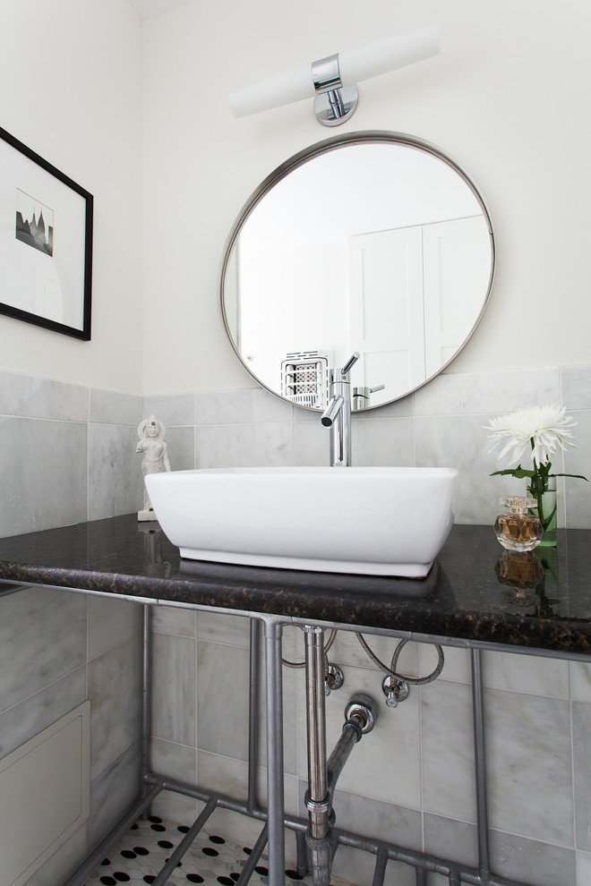 Modelo de aseo clásico renovado con lavabo sobreencimera, baldosas y/o azulejos blancos, paredes blancas, suelo con mosaicos de baldosas y encimeras negras
