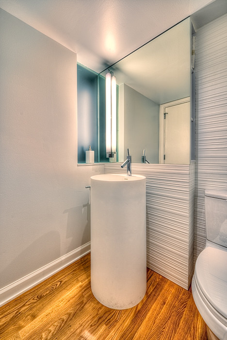 Inspiration för små moderna toaletter, med ett piedestal handfat, en toalettstol med separat cisternkåpa, vit kakel, porslinskakel, vita väggar och mellanmörkt trägolv