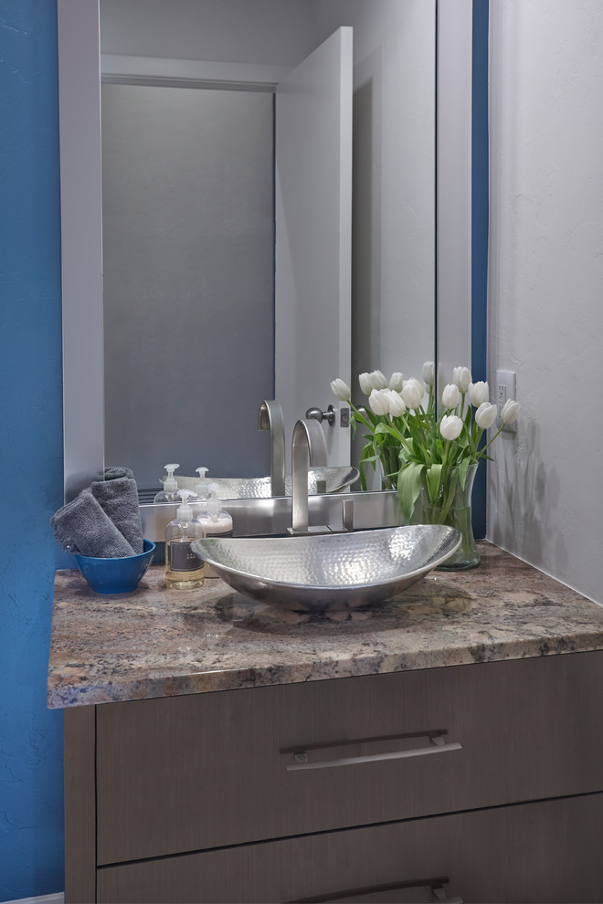 Exempel på ett mellanstort modernt toalett, med släta luckor, bruna skåp, blå väggar, klinkergolv i porslin, ett fristående handfat, granitbänkskiva och vitt golv