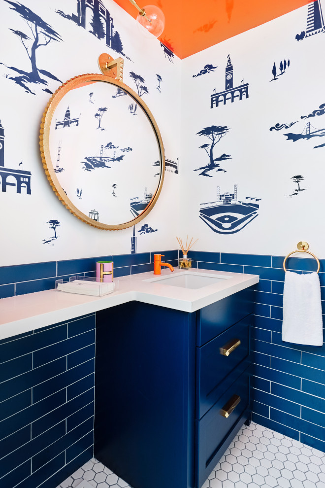 Пример оригинального дизайна: туалет среднего размера в стиле фьюжн с фасадами в стиле шейкер, синими фасадами, унитазом-моноблоком, синей плиткой, керамической плиткой, белыми стенами, полом из керамической плитки, врезной раковиной, столешницей из искусственного кварца, белым полом, белой столешницей и встроенной тумбой